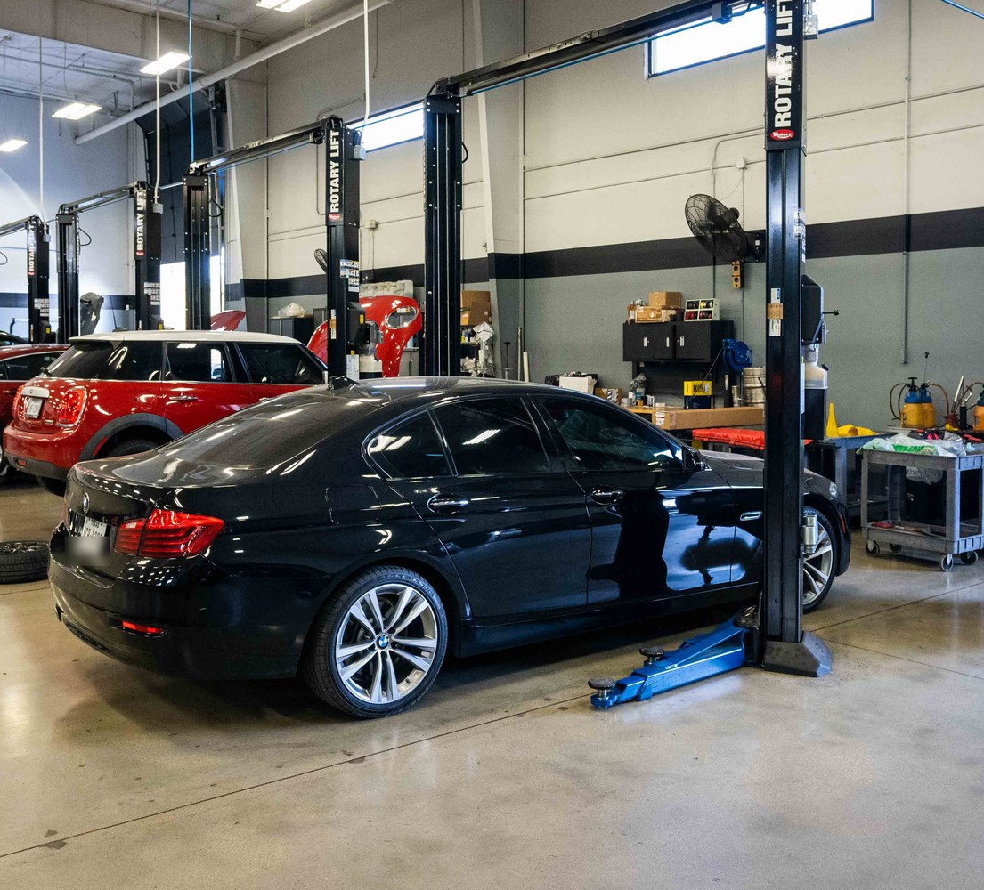 Luxury Auto Works shop floor with vehicles on lifts